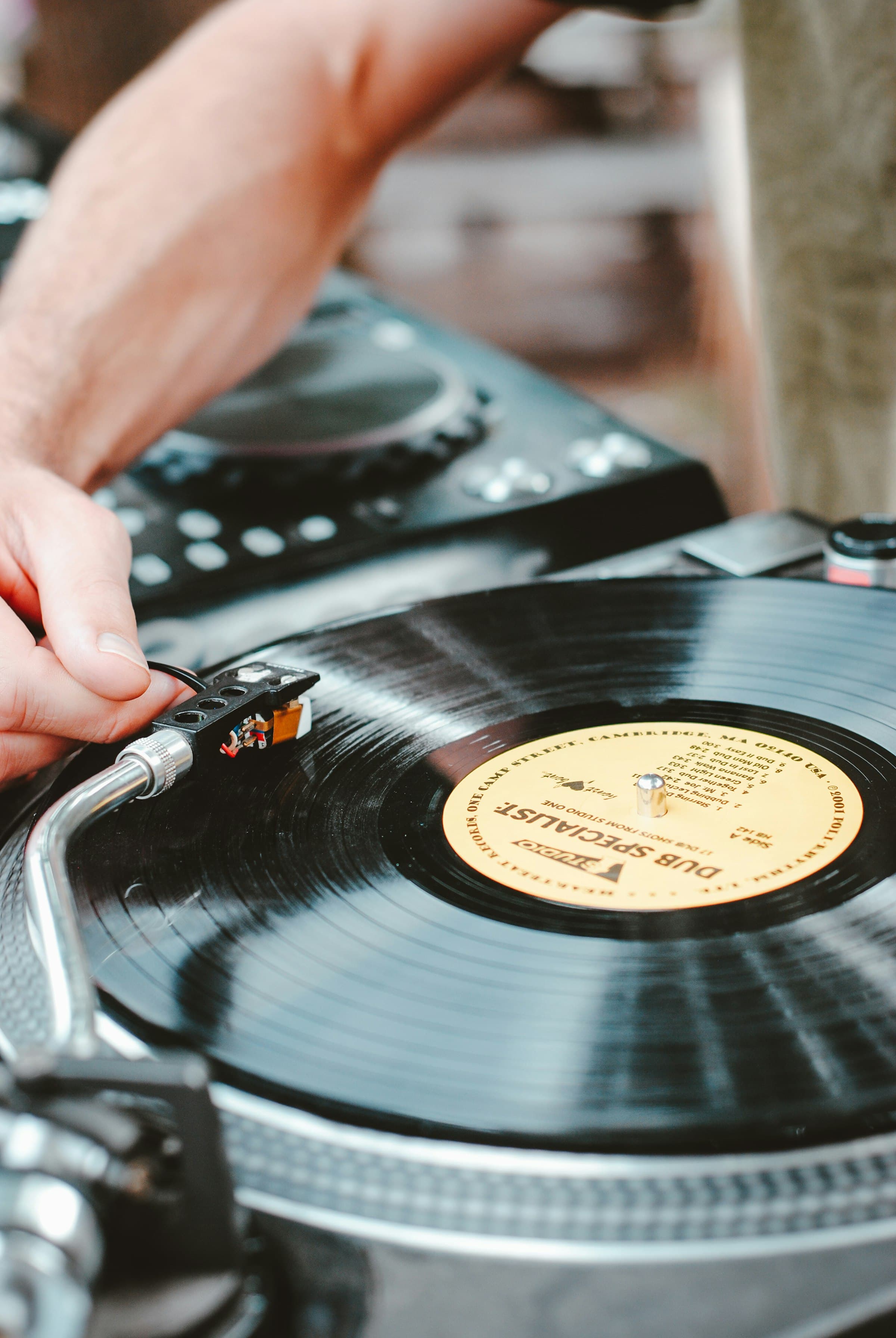 Vinyl record spinning on a turntable, a hand on the tonearm