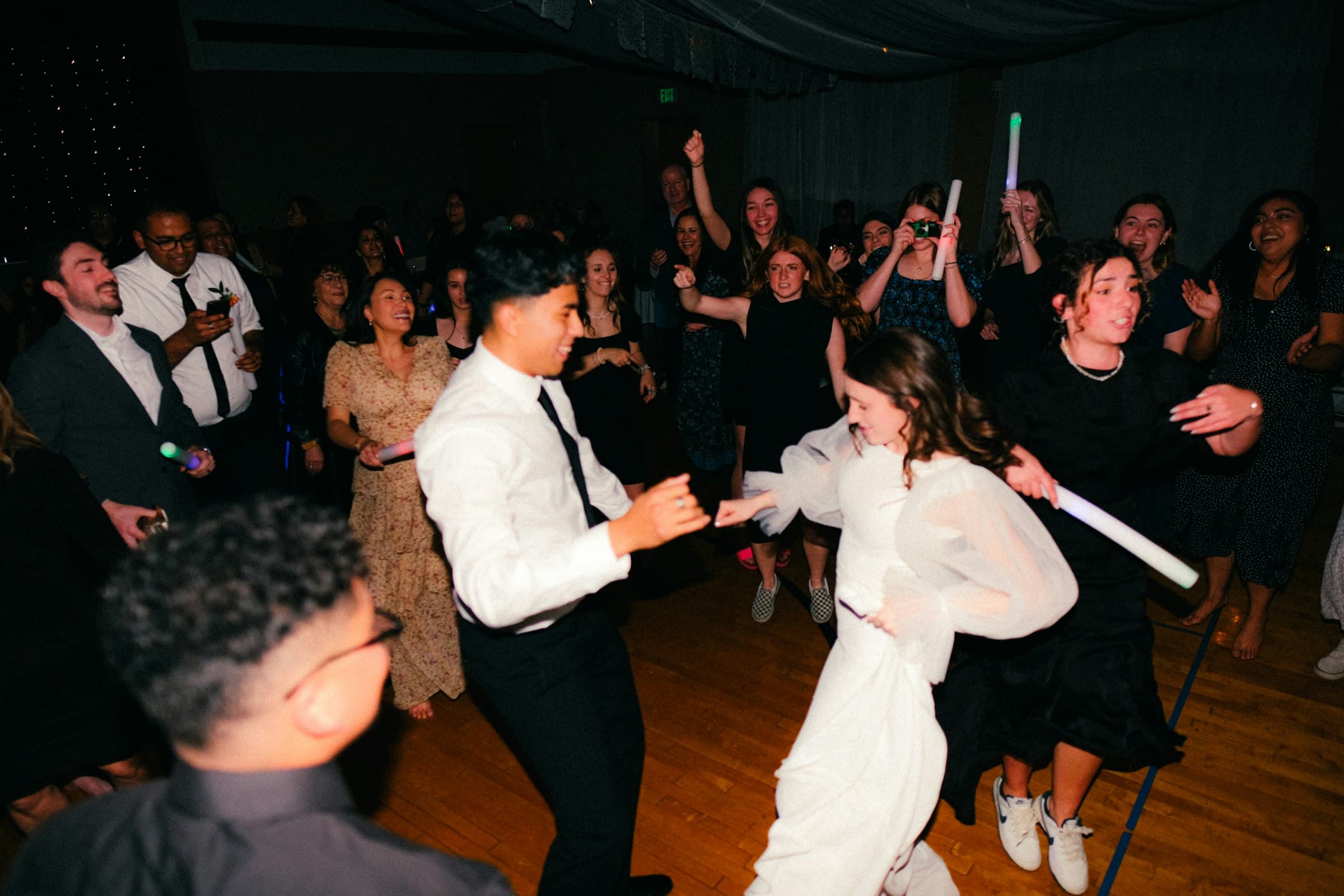 Dance floor at a reception, a bride in white mid-step