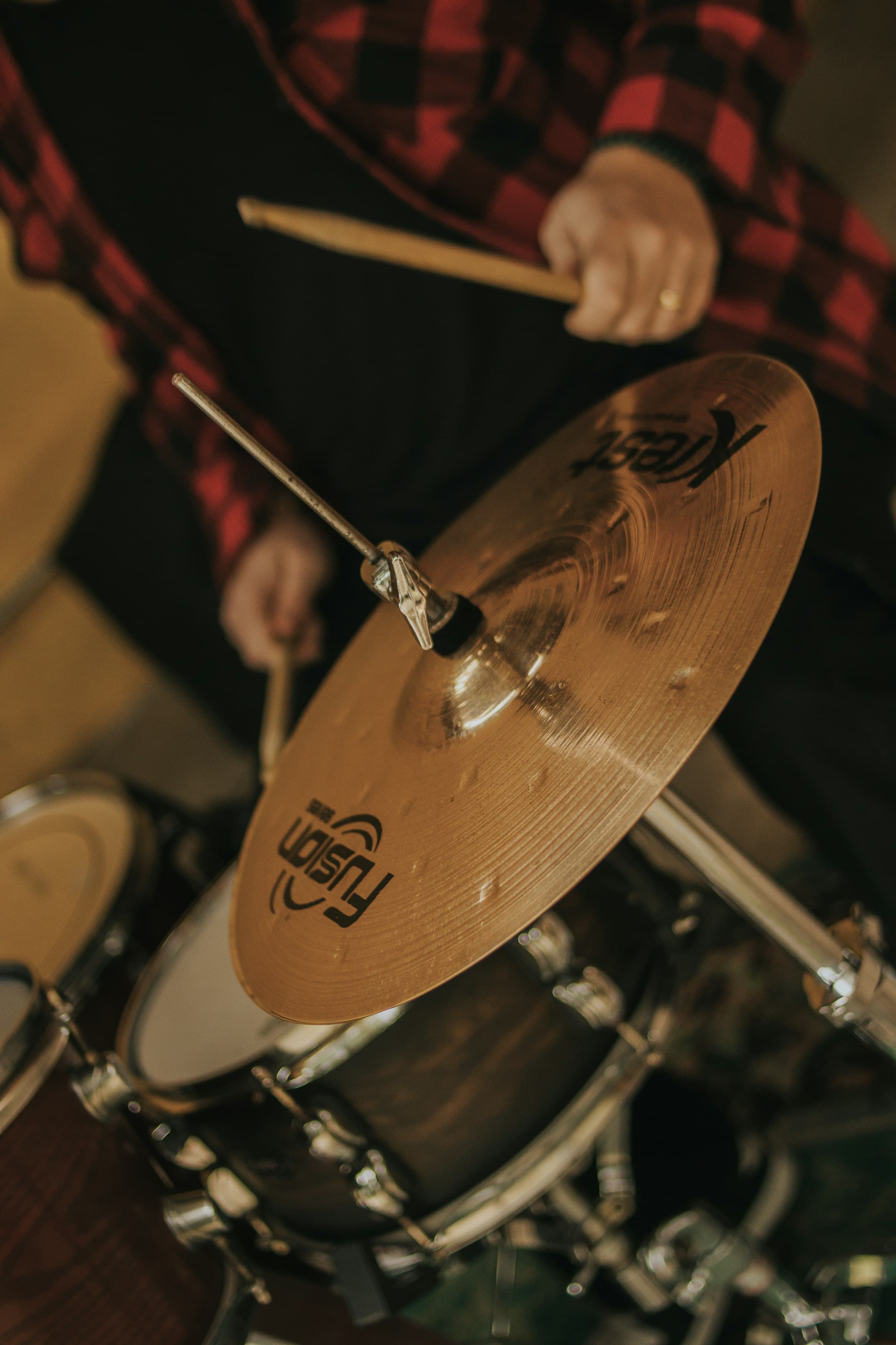 Drummer's hand and a cymbal, the kit blurred behind